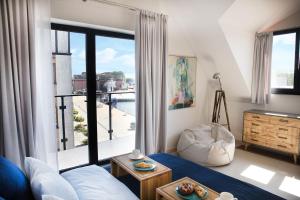 salon z łóżkiem i dużym oknem w obiekcie Apartamenty Port Ustka w Ustce