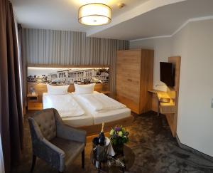 een hotelkamer met een bed en een stoel bij Hotel Schwarzer Adler Stendal in Stendal