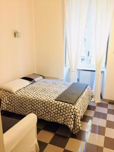 ein Schlafzimmer mit einem Bett und einem karierten Boden in der Unterkunft Bed2Go in Turin
