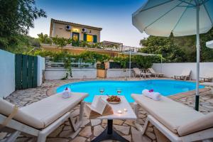 a villa with a swimming pool and a house at Elias Appartments in Longós