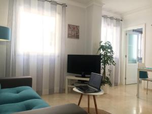 a living room with a laptop on a table with a tv at Apartamento beach house in Las Palmas de Gran Canaria