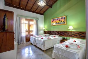 two beds in a room with green walls at Pousada Pedra Torta in Itacaré