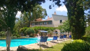 a house with chairs and a swimming pool at Marrucheto in Giuncarico