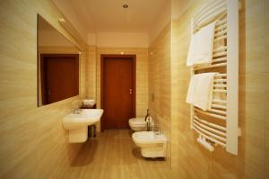 a bathroom with two sinks and a toilet and a mirror at Hotel Vis a Vis Łańcut in Łańcut