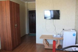 a room with a small table and a television on the wall at Адилет in Cholpon-Ata
