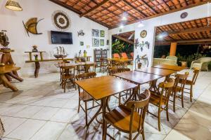 uma sala de jantar com mesas e cadeiras de madeira em Pousada Galeão Santa Anna em Barra Grande