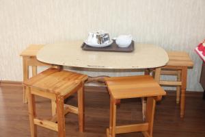 a wooden table with two chairs and a tea set on it at Адилет in Cholpon-Ata