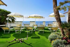 a patio with tables and chairs and the ocean at Villa delle Palme in Santa Marinella