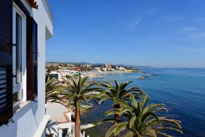 a view of the ocean and palm trees from a building at Villa delle Palme in Santa Marinella