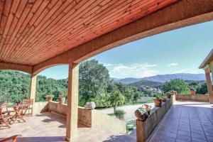 un patio al aire libre con pérgola de madera en A Ghjuvellina, en Piedigriggio