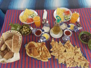 - Mesa con desayuno de tostadas, patatas fritas y bebidas en Casa La Hiba, en Chefchaouen