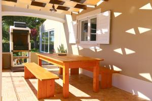 una mesa de madera y un banco en una habitación en Quinta do Pinheiro Manso - Holidays Villa - Marinha Beach, en Carvoeiro