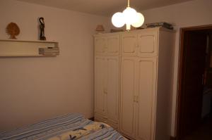 ザコパネにあるKrzeptówki 135のベッドルーム1室(ベッド1台、白い大型キャビネット付)