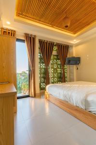 ein Schlafzimmer mit einem Bett und einem großen Fenster in der Unterkunft D Central Hoi An Homestay in Hoi An