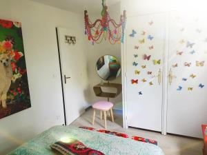 BorgoにあるMaison Lolly corse wifii freeのベッドルーム1室(ベッド1台付)、壁に蝶が飾られたクローゼットが備わります。