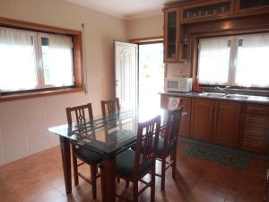 a kitchen with a table and chairs and a microwave at Casa do Reguengo in Arouca