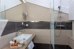 a bathroom with a sink, toilet and shower stall at Hotel Beau Rivage in Zermatt