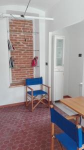 Cette chambre dispose d'une table, de chaises et d'un mur en briques. dans l'établissement LAGRANGE GALLERIA D'ARTE, à Turin