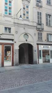 un bâtiment avec une arche au milieu d'une rue dans l'établissement LAGRANGE GALLERIA D'ARTE, à Turin