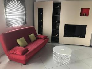 アンデルノ・レ・バンにあるvilla patio 150M²のリビングルーム(赤いソファ、テレビ付)