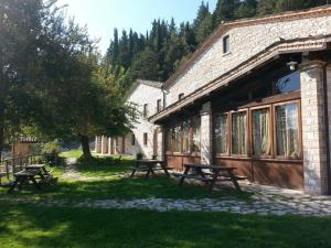 un grupo de mesas de picnic fuera de un edificio en Agriturismo Il Casale, en Pergola