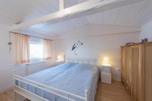 ノルダーナイにあるHaus Albatros App. Storchennestの白いベッドルーム(ベッド1台、ランプ2つ付)