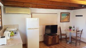 a kitchen with a refrigerator and a table with a tv at ZORBAS Sea View No 4 in Larnaca