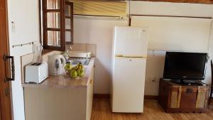 uma pequena cozinha com um frigorífico e uma televisão em ZORBAS Sea View No 4 em Lárnaca