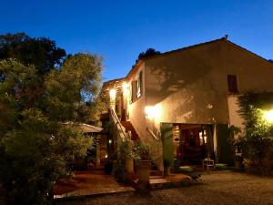 une maison la nuit avec les lumières allumées dans l'établissement Longo Maï, à Sillans-la-Cascade