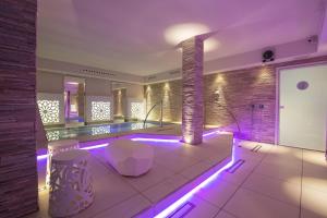 einen Pool mit lila Beleuchtung in einem Haus in der Unterkunft Hotel Parigi 2 & Spa in Dalmine