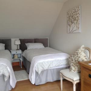 a bedroom with two beds and a chair at B&B at 37 in Anstruther