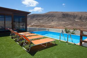 a patio with chairs and a pool with a view at Casa Guisguey in Guisguey