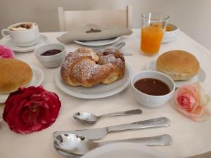 a table topped with plates of pastries and orange juice at Casale Colleoni in Tivoli