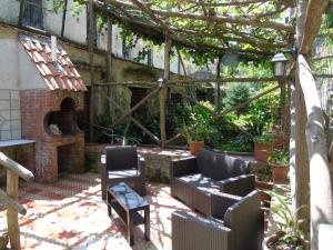 un patio al aire libre con sillas y un horno de ladrillo en Antica Cartiera Sant'Elia, en Tramonti