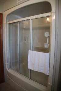 a towel hanging on a glass shower door in a bathroom at A Touch of Country B&B in Stratford