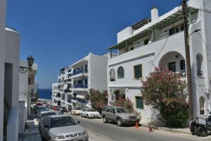 a city street with cars parked in front of buildings at Πικροδάφνες in Tinos