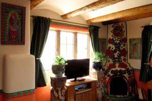 a living room with a tv and a fireplace at La Dona Luz Inn an Historic B&B in Taos
