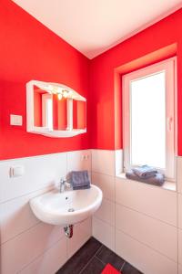 ゲーレンにあるVilla Mia Whg 2 mit Terrasse, EG 1 Raum Wohnungの赤いバスルーム(洗面台付)、窓