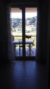 a room with a table and a window with a view of a balcony at Residence Mirage Milazzo in Milazzo