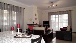 ein Wohnzimmer mit einem Tisch und Stühlen sowie ein Esszimmer in der Unterkunft Areias do Douro GuestHouse in Gondomar