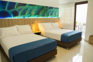 拉梅薩的住宿－Kau Hotel，酒店客房设有两张床,墙上挂有绘画作品