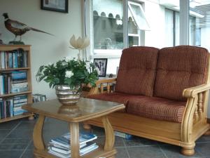 a living room with a couch and a table with flowers at Edenvale Bed & Breakfast in Portnoo