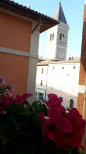 vista su un edificio con torre dell'orologio e fiori di Casa Medea a Gualdo Tadino