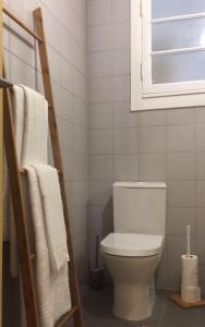 a bathroom with a toilet and a window and towels at Sant'Ana Guest House in Leiria