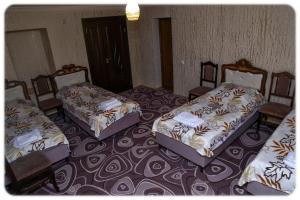 a room with three beds and chairs in it at Lucy B&B in Goris