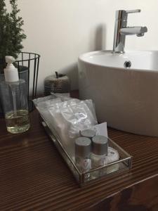 a bathroom with a sink and a tray with toiletries at Le Kraken Charme & Relax in Bergamo