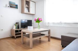 a living room with a table with a vase of flowers on it at Nauportus in Vrhnika