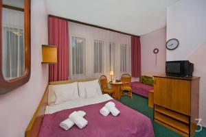 a hotel room with a bed with towels on it at Dom Wypoczynkowy Helunia in Jurata