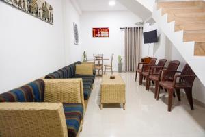a living room with couches and chairs and a table at White Rose Hostel in Kandy