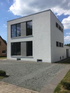 a white house with a driveway at Designer Studio Geestland in Langen